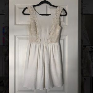 Dress. Short cream sundress with bodice detail.
